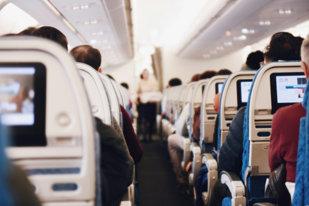 Rows of seated passengers on an airplane. Can You Legally Fly with Cannabis Edibles? Earthy Now