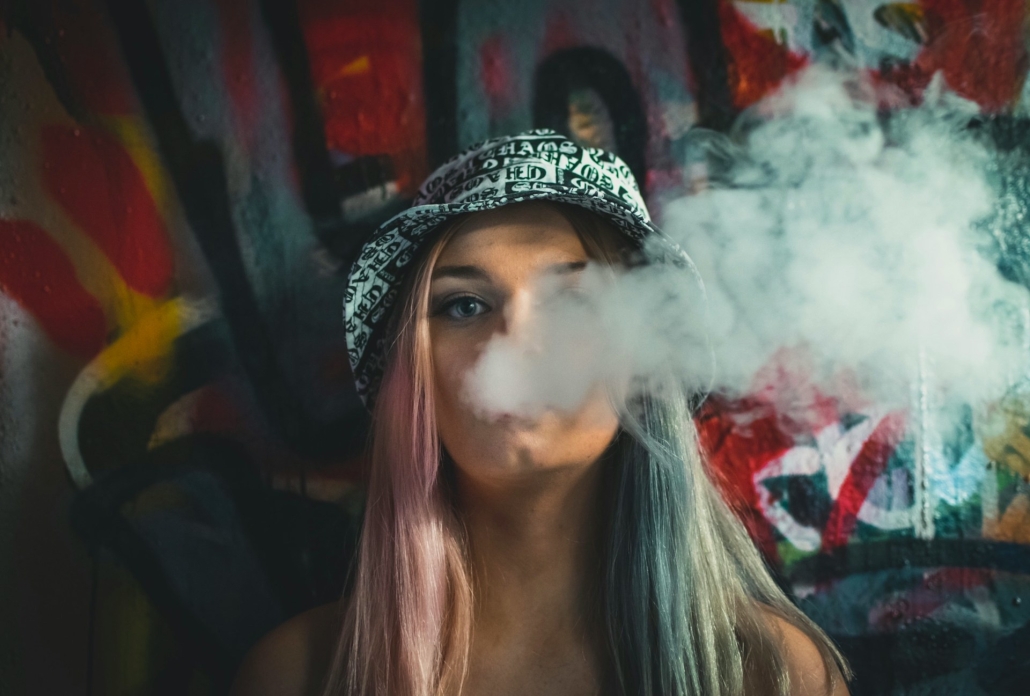 Woman exhales smoke - an example of DIY dosing when using cannabis. 